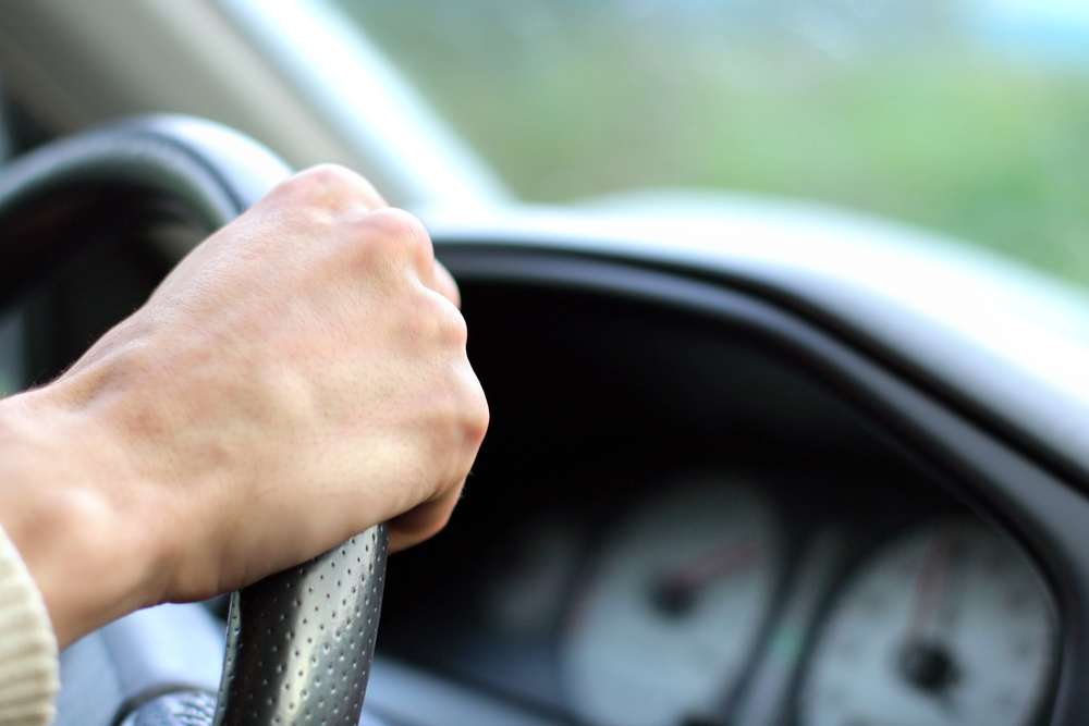 Hand op het stuur van een auto